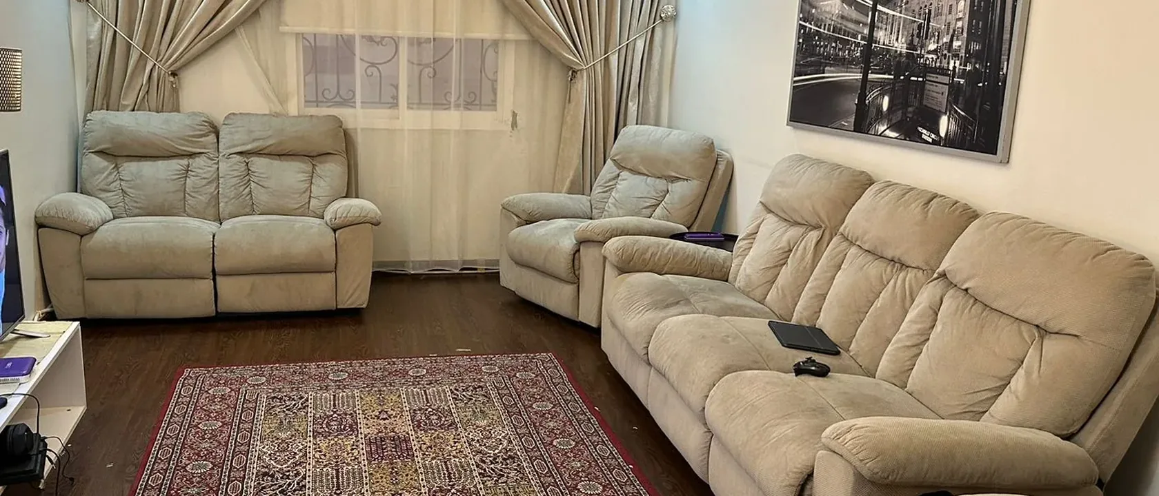 غرفة جلوس بطقم كنب فاتح وستائر وسجادة مزخرفة، مثال لمكان غسيل الكنب في البيت