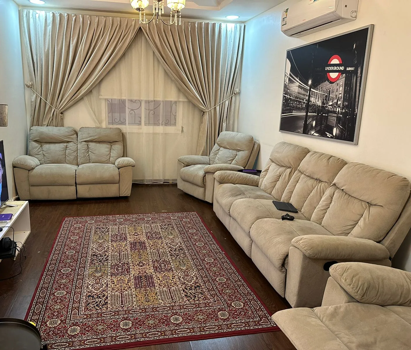 تنظيف مجالس بالرياض لغرفة جلوس فيها كنب فاتح وستائر وسجادة مزخرفة